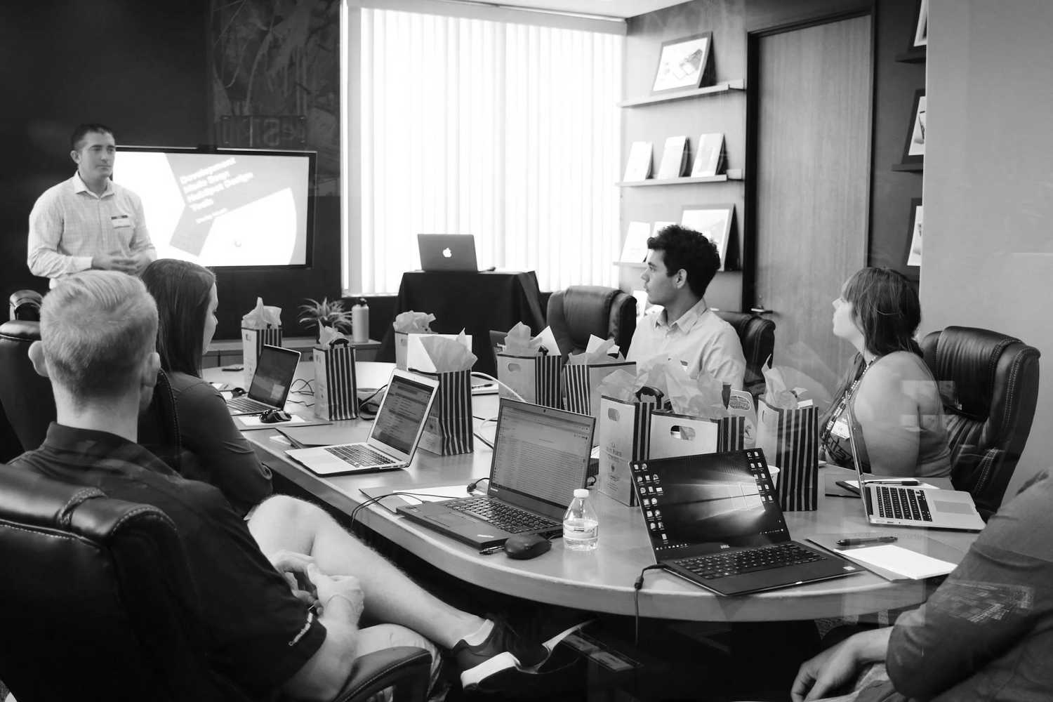 A team meeting around laptops and discussing work
